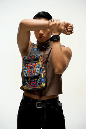 Person wearing a colorful and Compact travel sling bag carrying essentials with a plain background