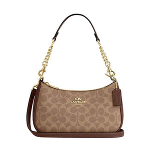 Coach handbag with gold chain strap on a light gray background
