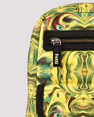 Texture detail of premium vegan leather sling bag with a zipper and 'Fetti' branding on a gray background