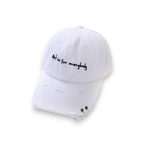A white baseball cap with the text 'Art is for everybody' printed on the front panel.