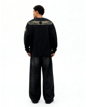 Person wearing a black outfit with gold screen print on the back against a white background
