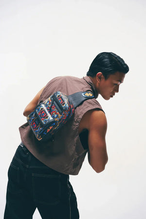 Back view of a Person wearing a black crossbody sling bag with a plain background
