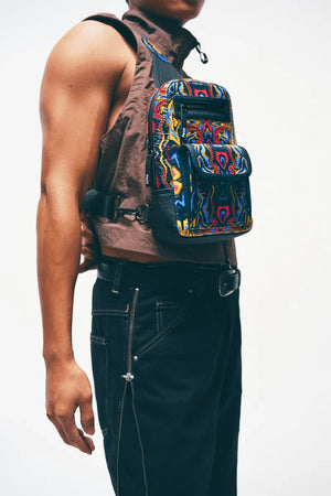 Close-up of zipper closure on a vegan leather sling bag worn by a man with a neutral background