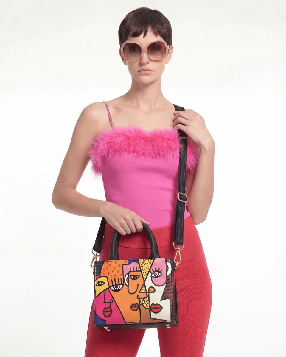 Woman holding a colorful Vegan tote bag Mini FETTI Faces on a white background